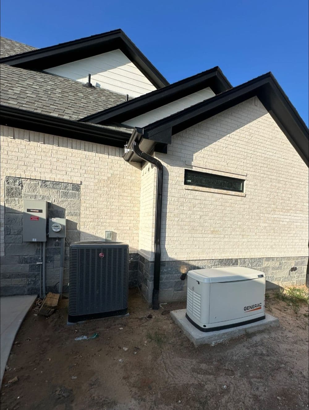 Home exterior featuring a Generac generator, HVAC unit, and utility meter against a brick wall.
